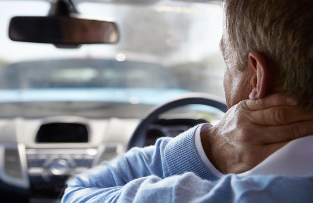 A magnifying glass inspecting a car for damage