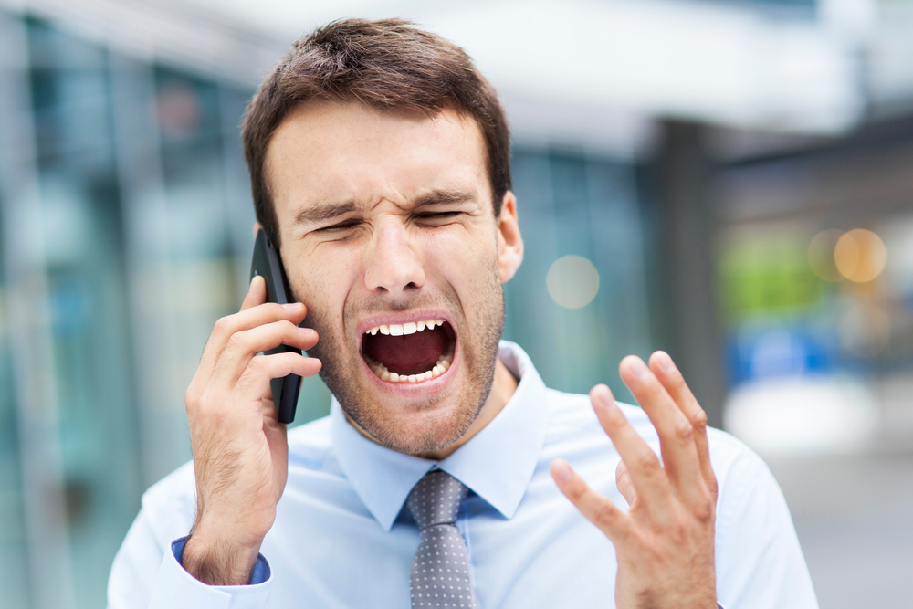 A person looking frustrated with a phone.